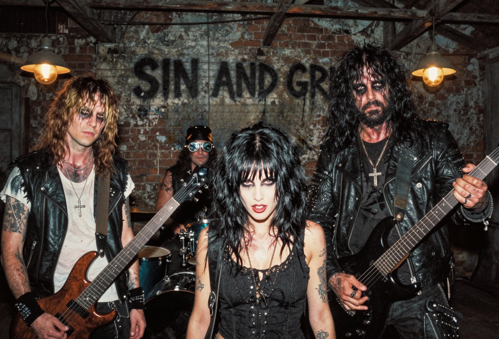 Sin & Grit in a brick-walled rehearsal space with guitars and drums